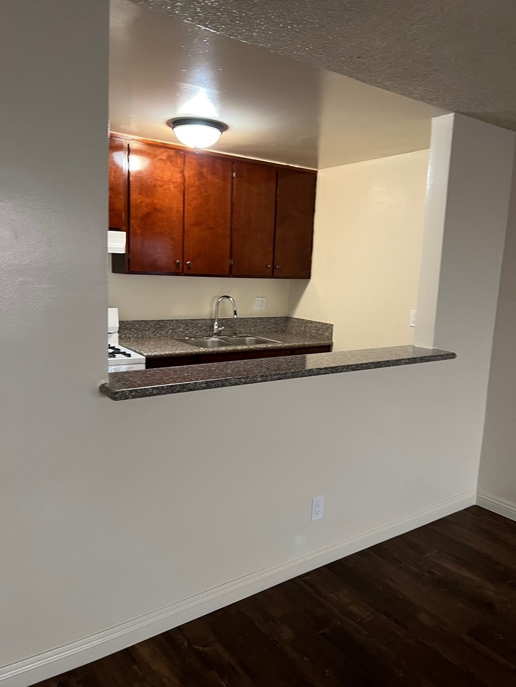 A kitchen with brown cabinets and a granite countertop.