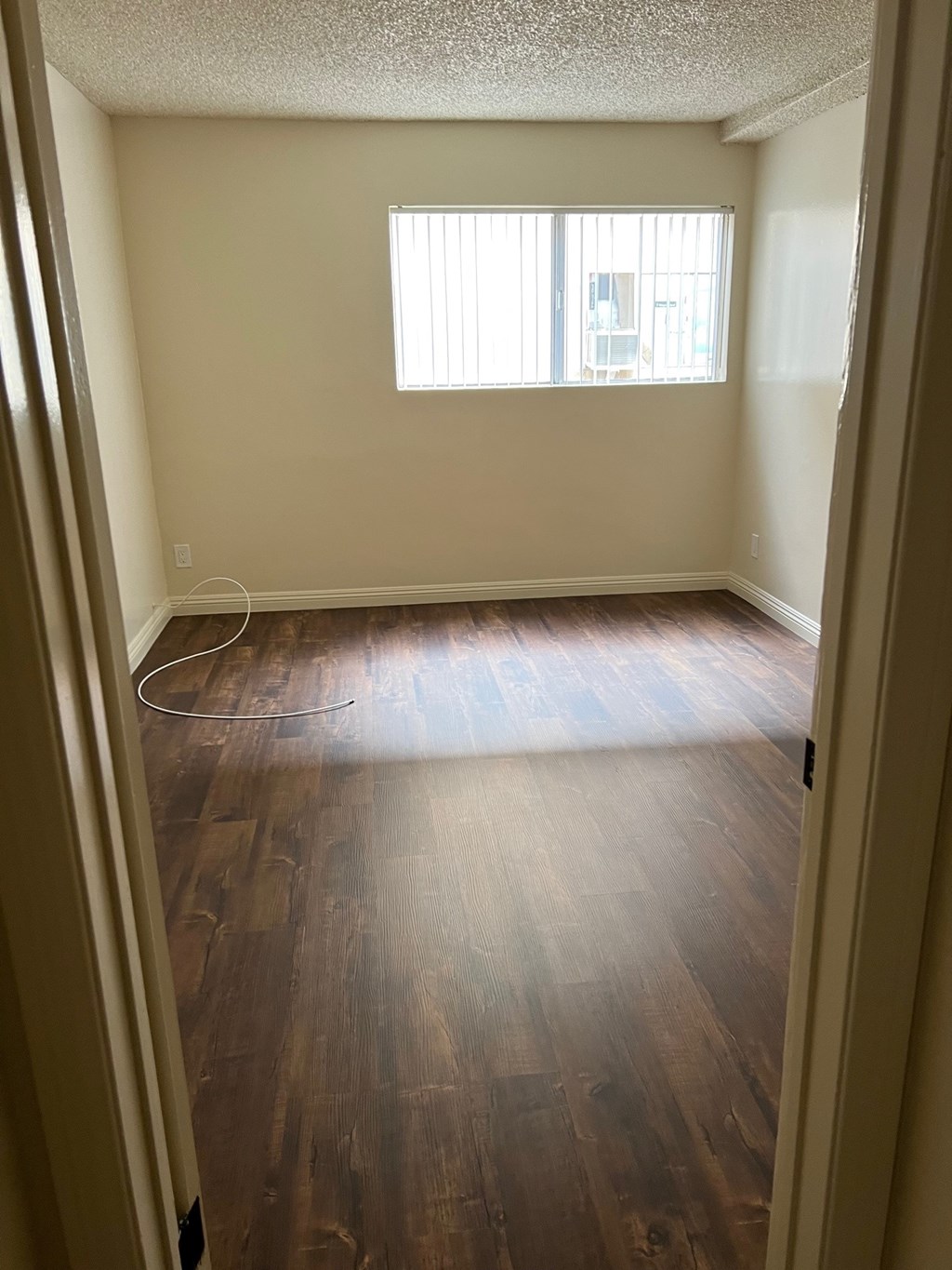 A room with wooden floors and a window.