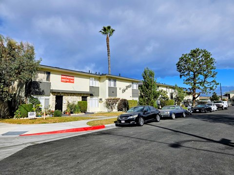 A parking lot with cars and a building in the background.
