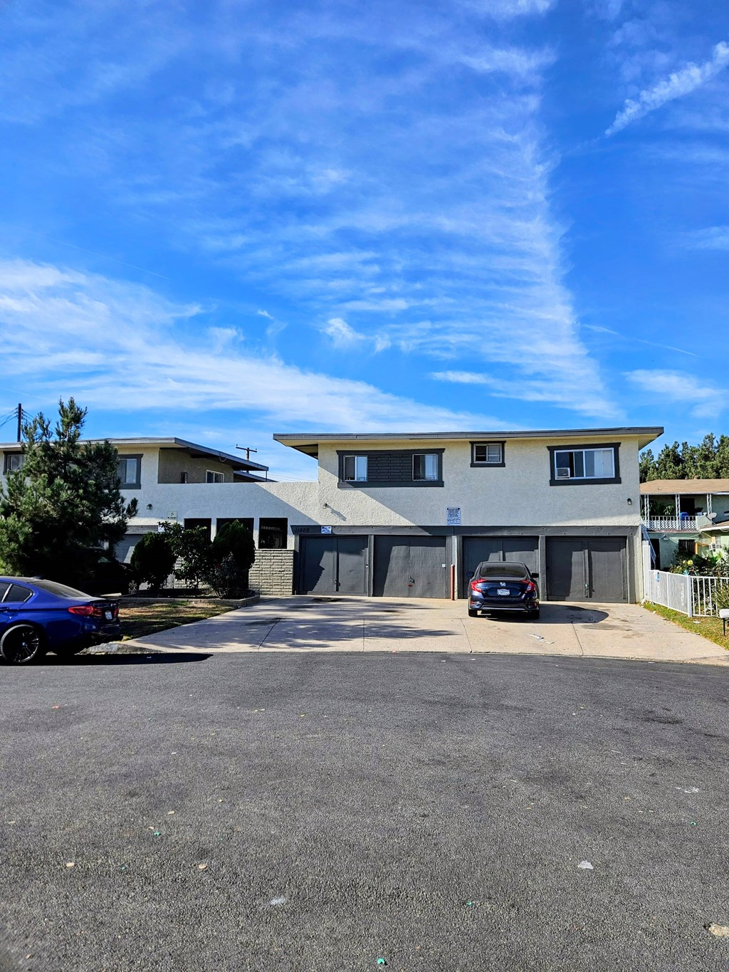 A modern two-story building with a parking lot in front.