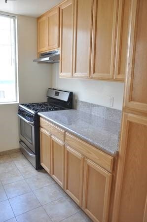 A kitchen with wooden cabinets and a black stove top oven.