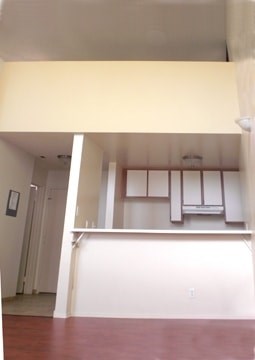 A room with a white wall and a brown floor.