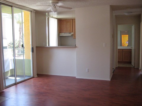 A room with a ceiling fan and sliding glass doors.