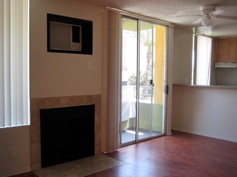 A room with a fireplace and sliding glass doors.