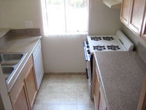 A kitchen with a stove top oven and a sink.