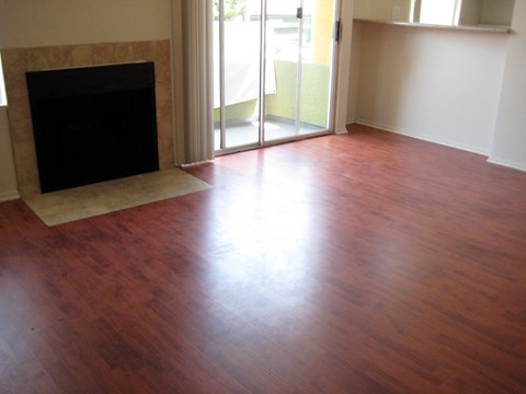 A room with a fireplace and wood flooring.