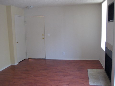 A room with a wooden floor and a white door.
