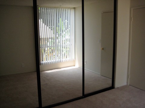 A room with a carpet floor and a glass door.