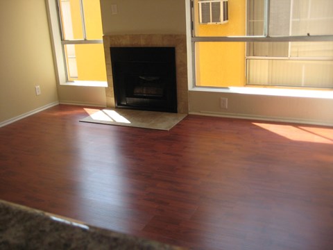 A room with a fireplace and wood flooring.