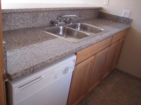A kitchen with a washer and dryer built into the counter.