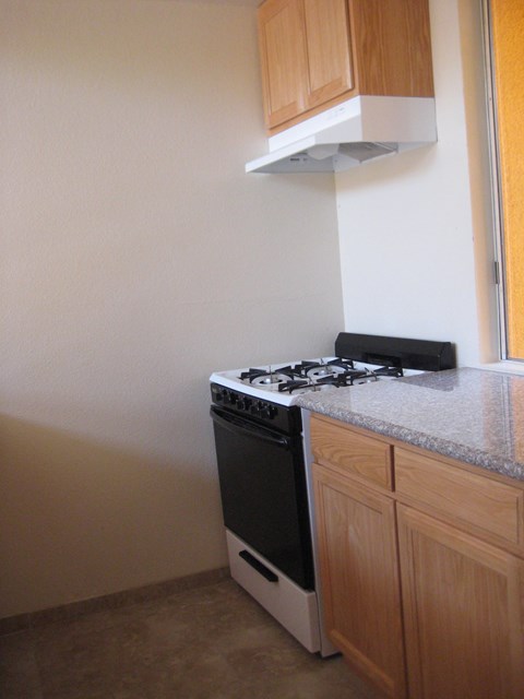 A black and white stove in a kitchen with wooden cabinets.