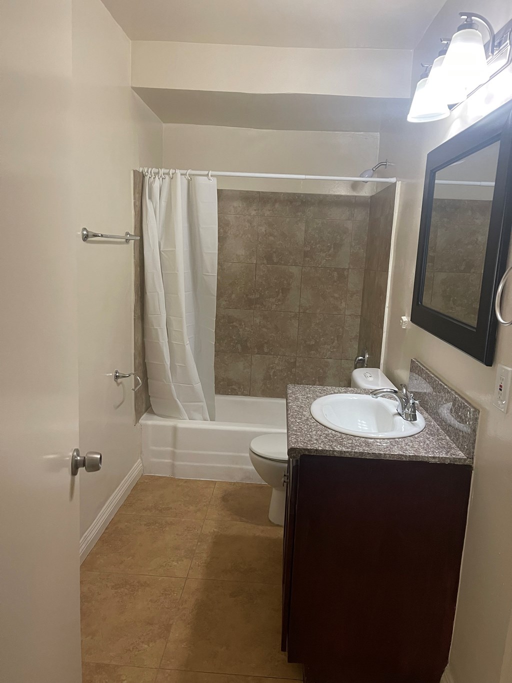 A bathroom with a sink, mirror, and shower.