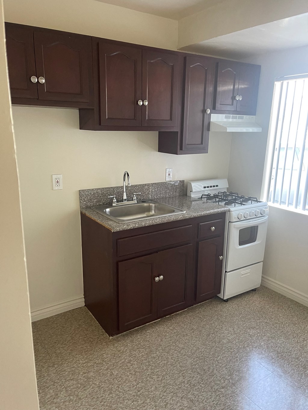 A kitchen with brown cabinets and a white stove.