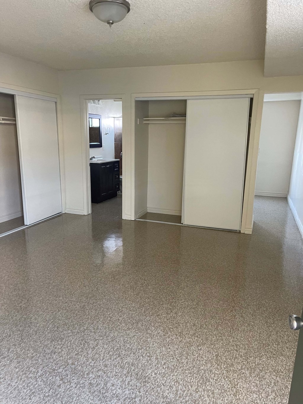 A room with a white floor and walls, and a ceiling light.