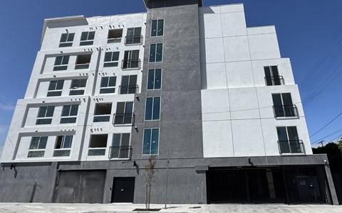 A modern building with a white and grey facade and multiple windows.