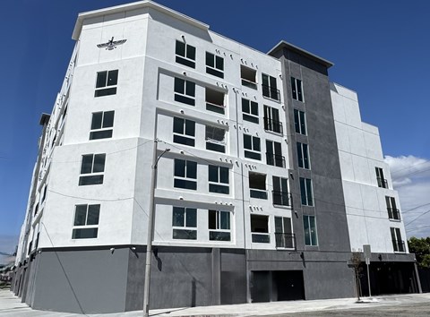 A white building with black windows and a black awning.