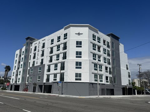 A large white building with a black emblem on the top left corner.