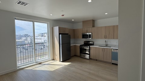 A kitchen with wooden cabinets and a black refrigerator.