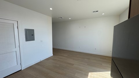 A room with a white door and a grey box on the wall.