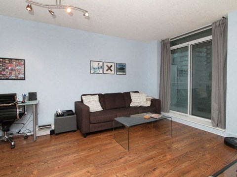 A living room with a brown couch and a coffee table.