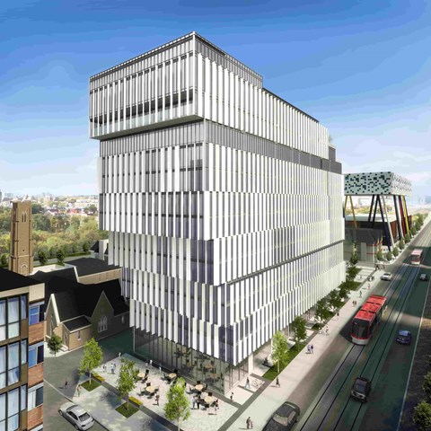 A modern building with a lot of windows is being constructed next to a road.