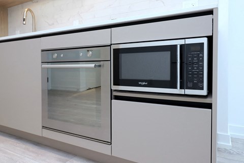 A modern kitchen with a built-in oven and microwave.