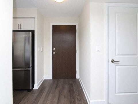 A kitchen with a refrigerator and a door.