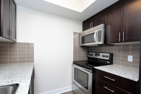 A kitchen with a stove top oven and microwave above it.