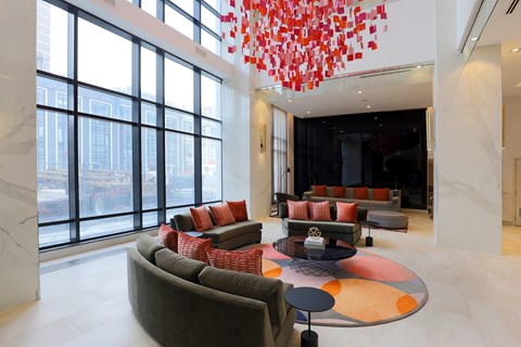 A modern living room with a large window and a chandelier.