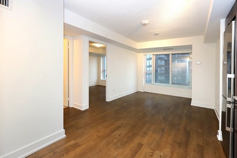 A spacious room with wooden floors and white walls.
