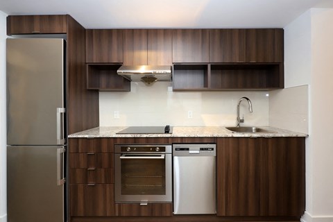 A modern kitchen with a stainless steel refrigerator and wooden cabinets.