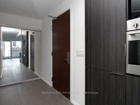 A modern kitchen with dark wood cabinets and a stainless steel oven.