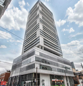 A tall building with a curved top and a striped facade.