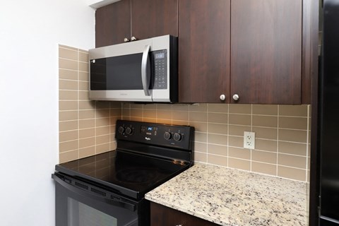 A kitchen with a black oven and a microwave above it.