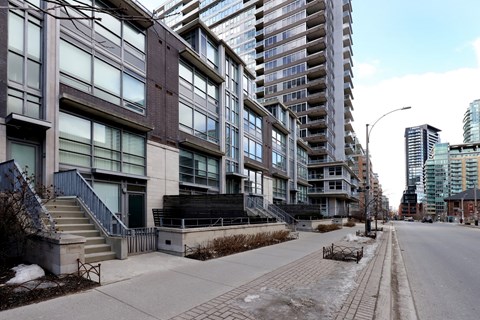 A long building with a lot of windows is on the left and a shorter building with a lot of windows is on the right.