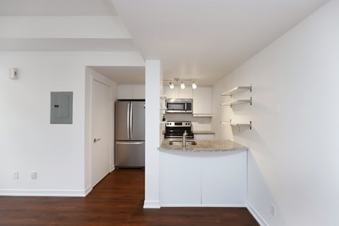 A kitchen with white cabinets and a stainless steel refrigerator.