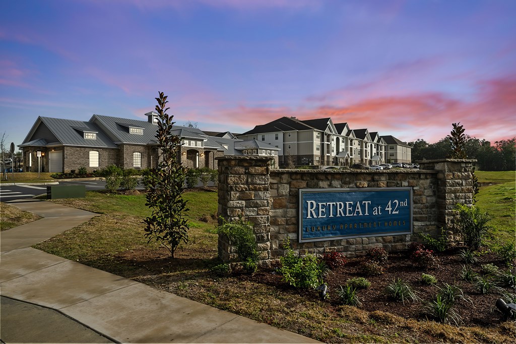 A sign that says "Retreat at 42nd" is in front of a building.