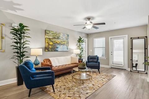 A living room with a blue chair and a brown couch.