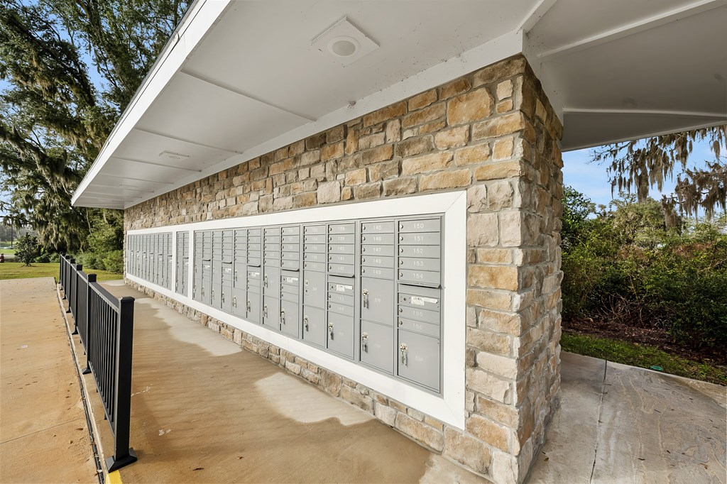 A row of mailboxes are mounted on a stone wall.