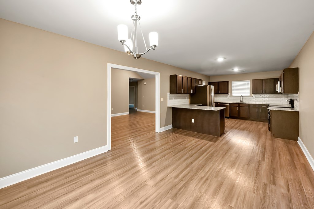 A kitchen with wooden floors and a chandelier.