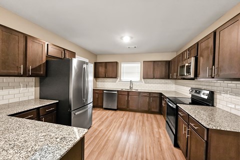 A kitchen with wooden cabinets and black appliances.