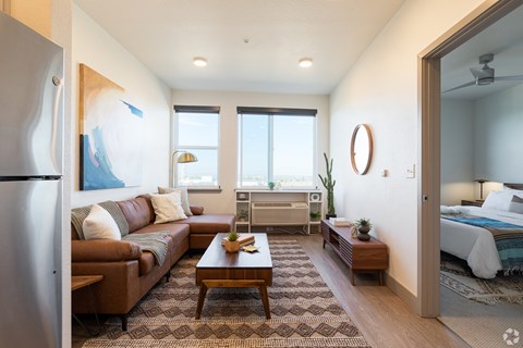 A modern living room with a brown leather couch and a wooden coffee table.