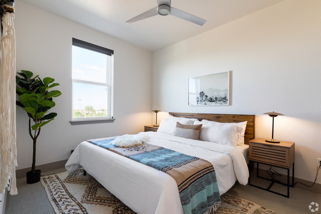 A bedroom with a large bed and a ceiling fan.