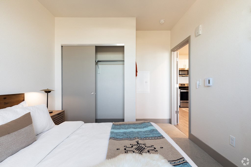 A bedroom with a bed, a rug, and a door.