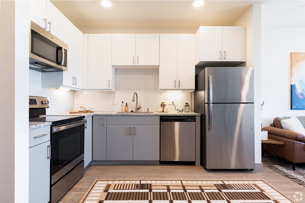 A modern kitchen with stainless steel appliances and white cabinets.