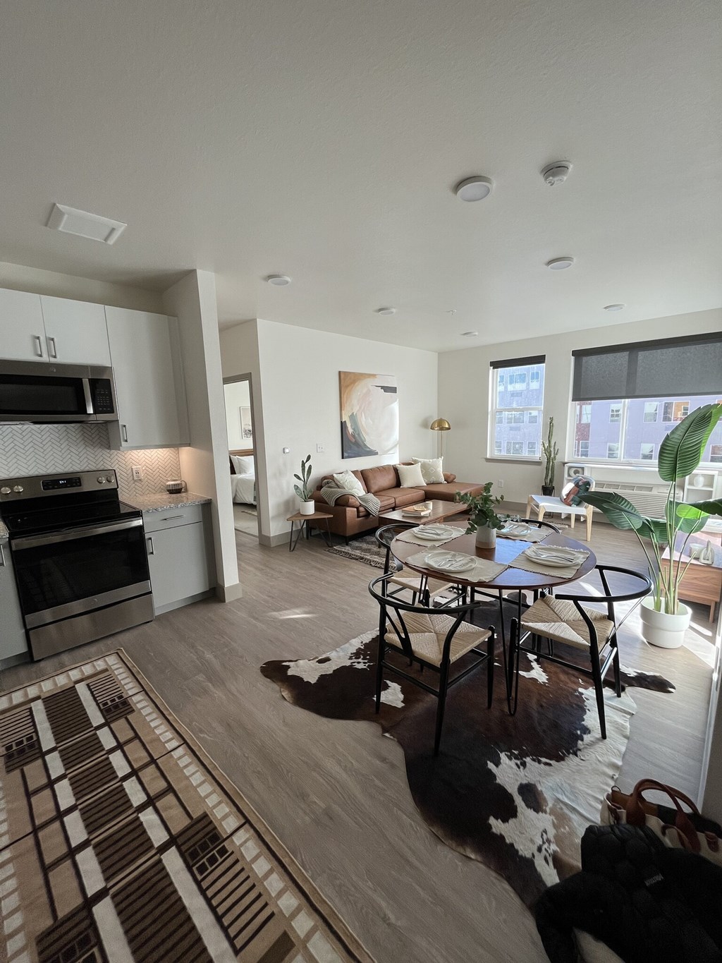 A modern kitchen with a dining table and chairs in the middle of the room.