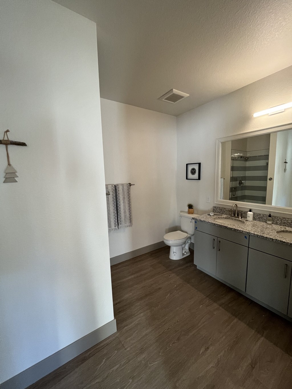 A bathroom with a toilet, sink, and mirror.