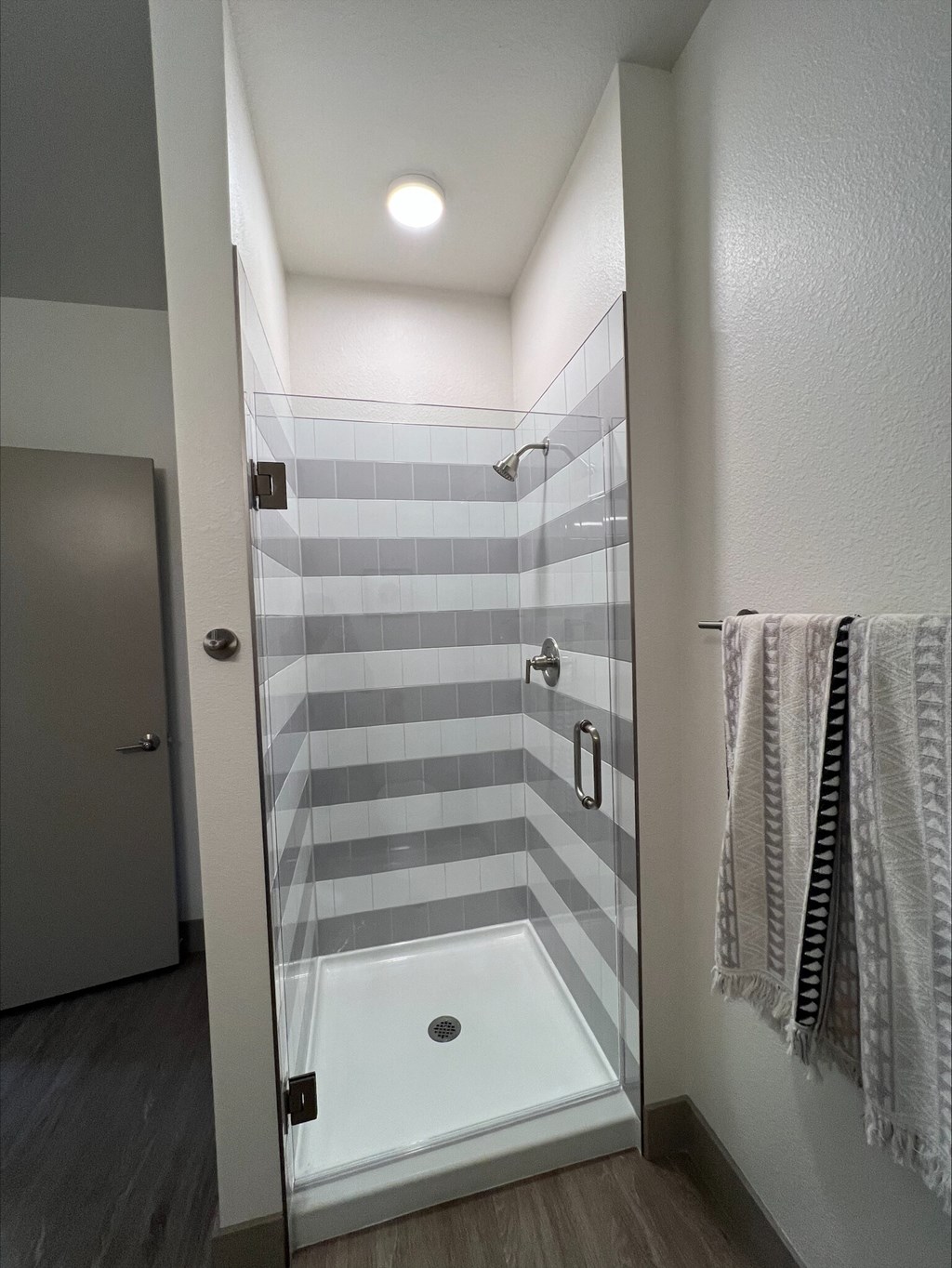 A bathroom with a walk in shower and a towel rack.