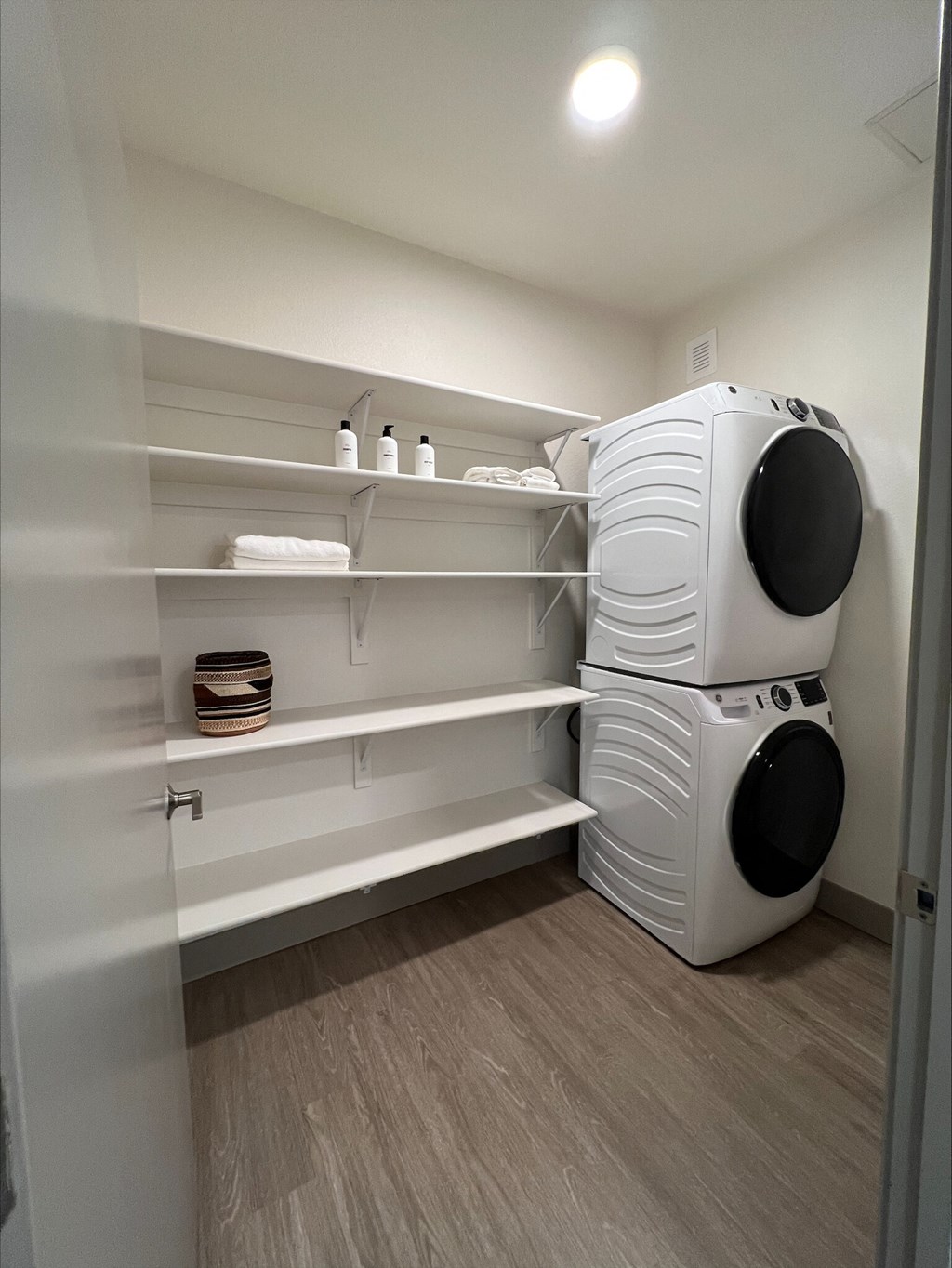 A white laundry room with a washer and dryer stacked on top of each other.