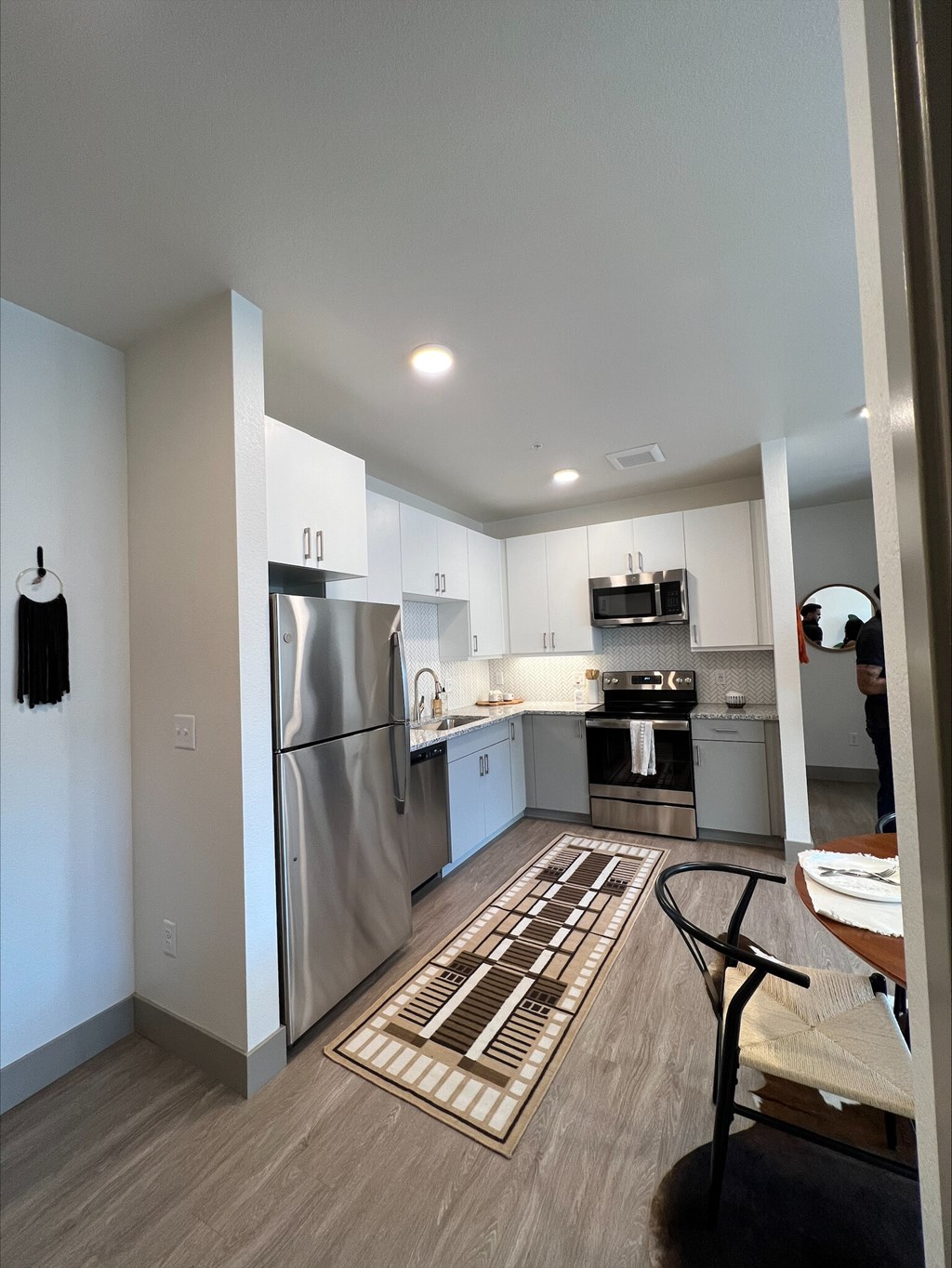 A kitchen with a refrigerator, oven, and sink.